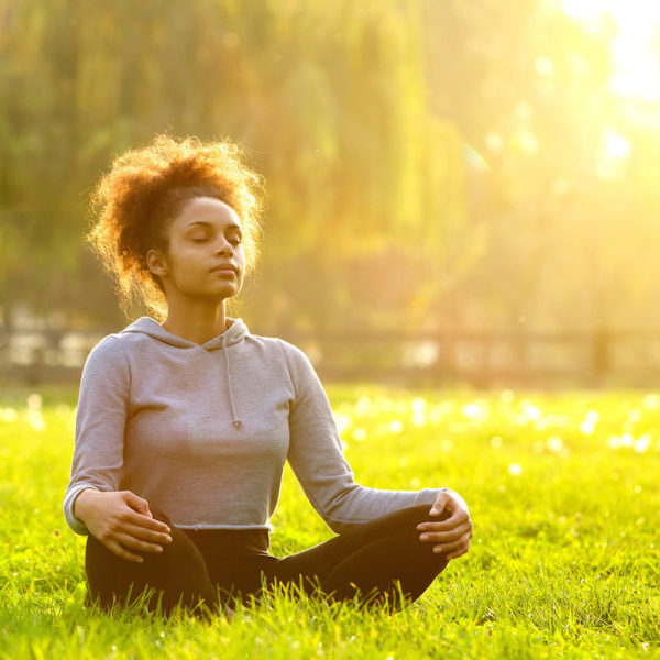 Young african american woman meditating in nature